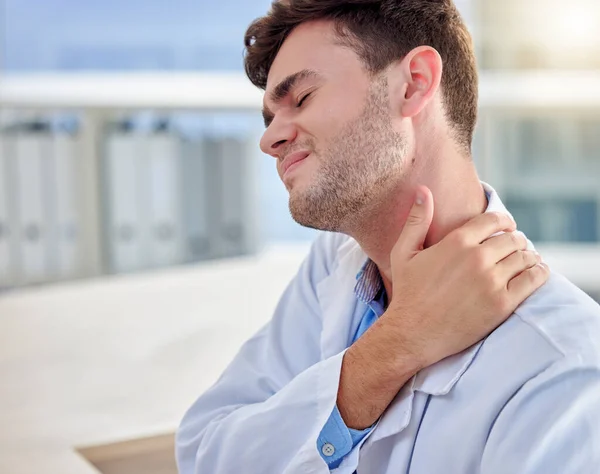 Tired, stress and man or doctor neck pain in office overworked, burnout or tension for healthcare problem. Medical professional worker, frustrated person or nurse with muscle injury at desk.