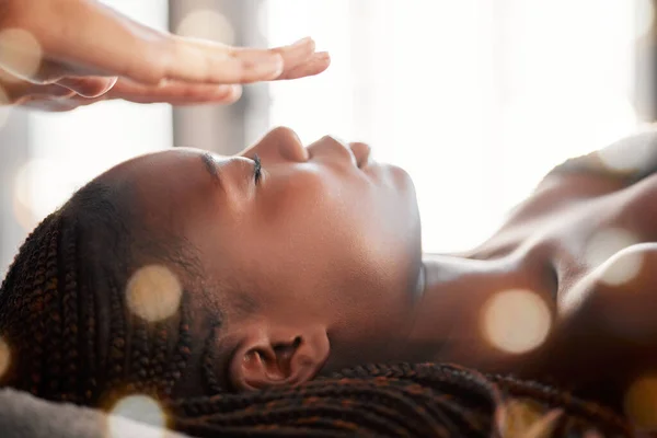 Black woman, relax and reiki spa treatment of a young female ready for facial. Skincare, beauty and salon wellness clinic with client feeling calm and zen from massage and holistic dermatology.