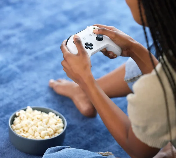 Woman, video games and hands playing on home floor with popcorn for online gaming, gamepad and relax. Gamer person play on console, joystick or control for esports, streaming and cyber world tech.