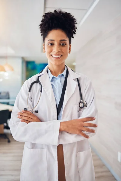 stock image Portrait, black woman and doctor arms crossed, healthcare and smile in hospital, leader and confident. Face, African American female surgeon, employee or medical professional with skills or happiness.