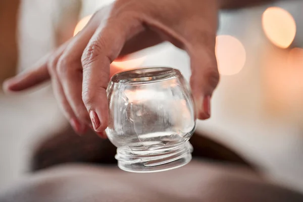 Cupping therapy, glass vacuum cup in hand and woman at spa, therapist with deep tissue massage and wellness. Closeup, treatment at luxury resort with cosmetic, body care and health with acupuncture.