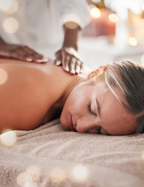 Woman, back massage at spa and holistic therapy with masseuse hands, wellness and treatment with zen. Health, peace of mind and stress relief, self care and lifestyle with healing, face and calm.