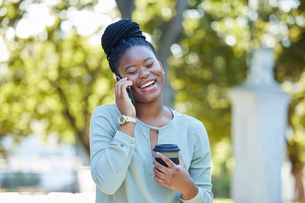 Black woman, phone communication and morning outdoor with blurred background and laughing. Smile, networking and business employee on a work break on a mobile conversation and discussion by trees.