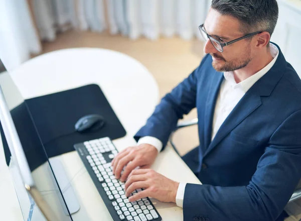 彼は仕事の上にいる オフィスでノートパソコンを使っているビジネスマンが — ストック写真