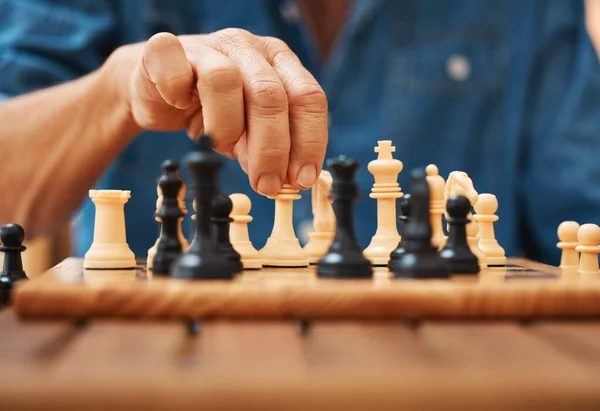 A skilled hand deftly slides a chess piece marked Chess across