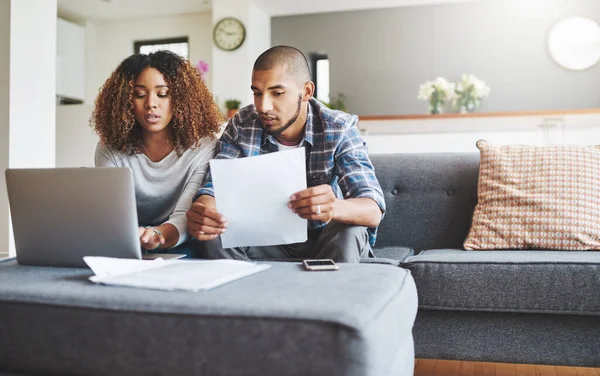 stock image Shot of a young couple going through their paperwork together at home.