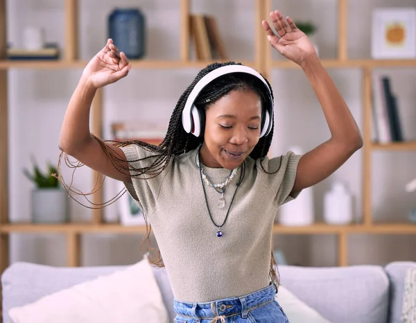 Black woman, dancing and music headphone in home living room with energy and wifi connection. Young person dance while listening to audio, sound and radio or podcast for freedom, motivation and relax.