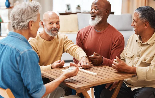 Senior men, friends and dominoes in board games on wooden table for activity, social bonding or gathering. Elderly group of domino players having fun playing and enjoying entertainment at home.