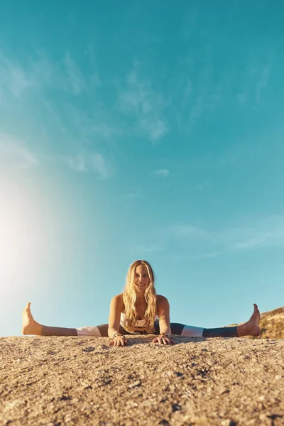 stock image Shot of an athletic young woman practicing yoga on the beach.