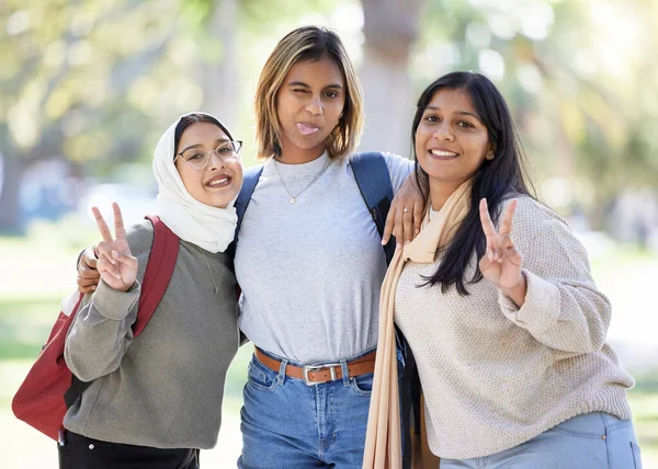 Women, friends or peace sign portrait in park, nature garden or school campus in diversity bonding, comic play or goofy community. Smile, happy or Muslim students and funny face, tongue or silly face.