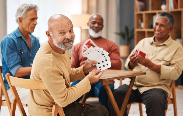 Showing, portrait and senior friends with cards for a game, playing and bonding in a house. Smile, show and elderly group of men in a nursing home for poker, games and competitive for fun together.