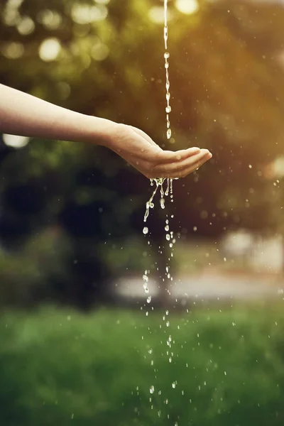 外の女性の手の上で実行している水の作物のショット — ストック写真