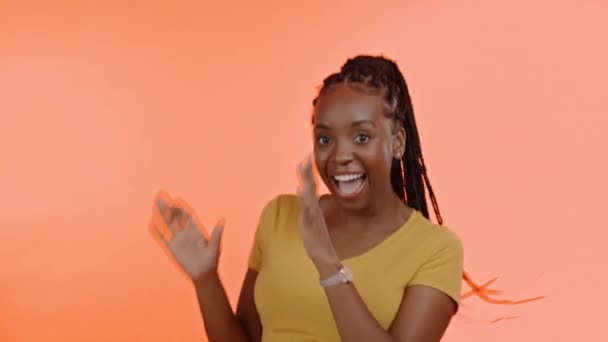 オレンジの背景のお祝い 勝利と拍手に隔離された黒人女性の成功 ダンス 興奮した勝者 スタジオダンスのアフリカ人やモデル 競争のためのお祝いとエネルギー — ストック動画