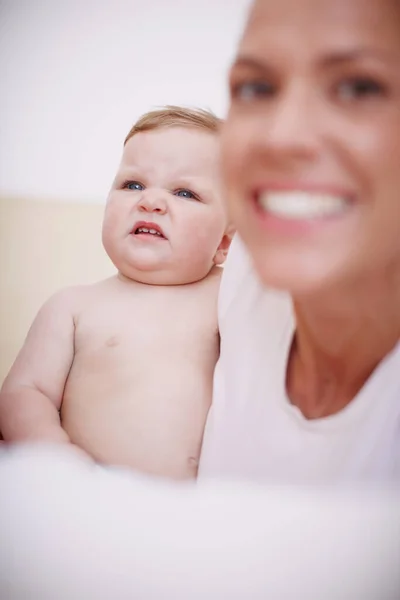 彼女は一番かわいい顔をしている 母親の隣に座って顔を作っている赤ん坊は — ストック写真