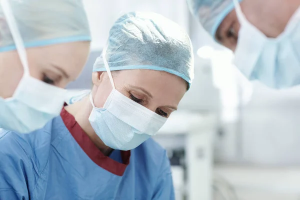 落ち着いて集中医療専門家 手術中の同僚と働く女性外科医の閉鎖 — ストック写真