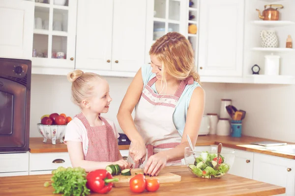 サラダの作り方を教える 若い母親と娘が一緒にサラダを作る — ストック写真