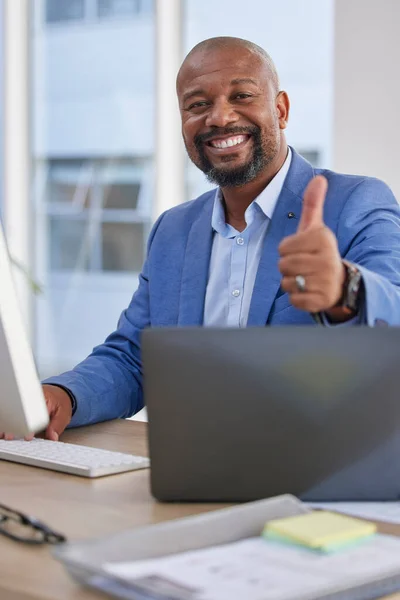 Happy black man, laptop and thumbs up for winning, good job or success in marketing at the office desk. Portrait of African American male showing thumb emoji, yes sign or like in thanks by computer.