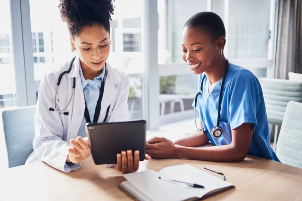 Tablet, black woman or doctors with medical research reading news or tests results in hospital together. Teamwork, digital tech or African nurses planning or speaking of healthcare report on website.