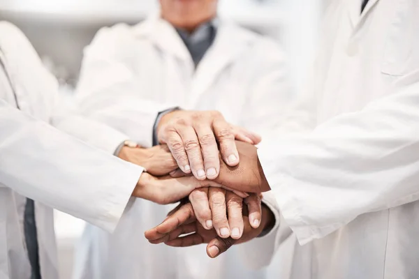 Doctor, team and hands together in healthcare, partnership or trust for collaboration, unity or support at lab. Group of medical experts piling hand in teamwork for motivation, cooperation or union.