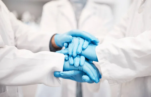 Doctor, team and hands together with gloves in healthcare, partnership or trust for collaboration, unity or support at lab. Group of medical experts piling hand in teamwork for motivation or safety.