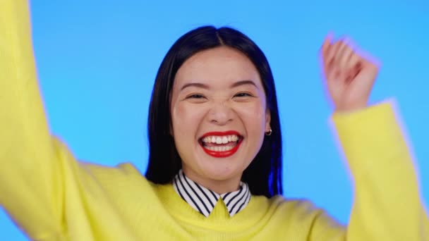 アジアの女性は 肖像画やお祝いのための手で興奮し 青の背景に勝つか または販売 スタジオでのニュース発表 プロモーション契約 または競争の勝者を応援ハッピーモデルの人 — ストック動画
