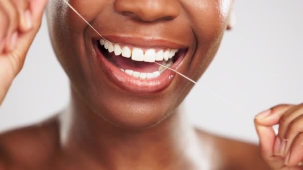 手と黒の女性のスタジオでは灰色の背景に隔離された歯を流れる 歯のケア 口腔健康と歯のクリーニング 個人的な衛生とガムの健康のための花と幸せな女性モデル — ストック動画