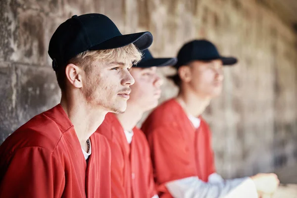 Baseball, team and dugout with a sports man watching a competitive game outdoor during summer for recreation. Sport, teamwork and waiting with a male athlete on the bench to support his teammates.