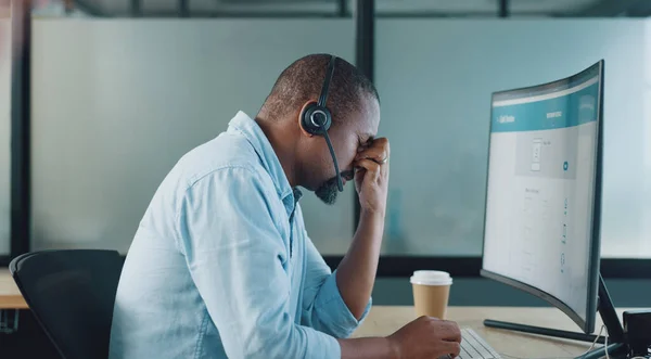 Call center, black man and headache on computer from stress, burnout and desktop glitch, pain and crisis. Frustrated telemarketing consultant tired of pc web problem, poor sales service and challenge.