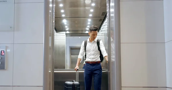 stock image Elevator, travel and watch with a business asian man in an airport, checking the time of his flight for departure. Door, floor and late with a male employee holding suitcase luggage while traveling.