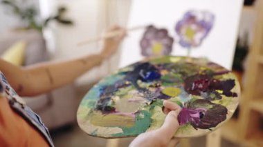 Renk paleti olan el, boya ya da sanat eserleri ve evinde yaratıcı ifade ya da sanat eserleri için bir kadın ressam. Resim, atölye ve stüdyosunda tuval üzerinde çalışan bir kadın sanatçıdan ilham almak..