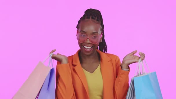 黑人女人 购物袋和工作室 脸上带着兴奋的表情 网上销售 快乐而有紫色背景的衣服 非洲女孩 笑和肖像零售折扣 商店交易和时尚 — 图库视频影像