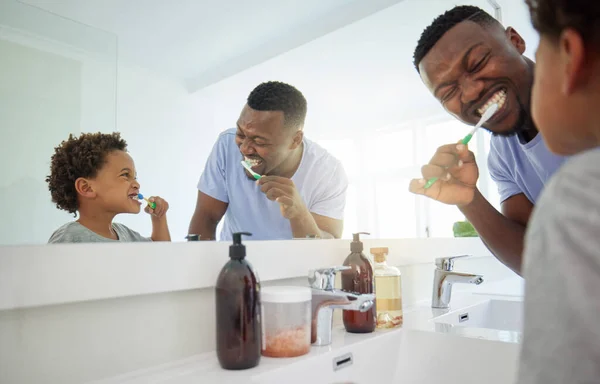 Dental hygiene, father and son brushing teeth, morning routine and wellness in bathroom with smile. Love, dad and boy oral health, cleaning mouth and child development with happiness and self care.