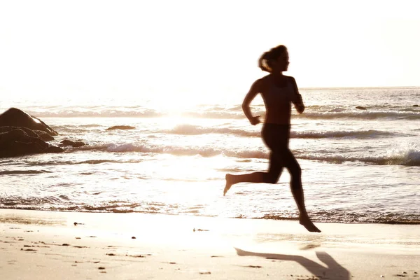 日没時に海岸を走る若い女性 日没時に海岸を走る若い女性の肖像画 — ストック写真