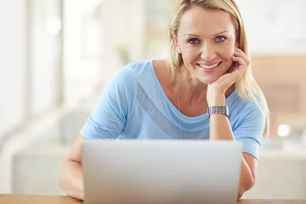 stock image I am at my happiest when Im blogging from home. Cropped portrait of an attractive mature woman sitting and using a laptop while in her living room during the day