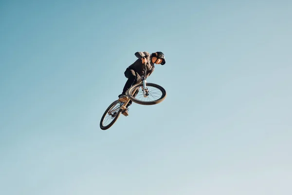 Motorcycle stunt, man cycling in air jump on blue sky mock up for sports action performance, fitness training or outdoor bike performance. Professional sports person with bmx bicycle adventure mockup.