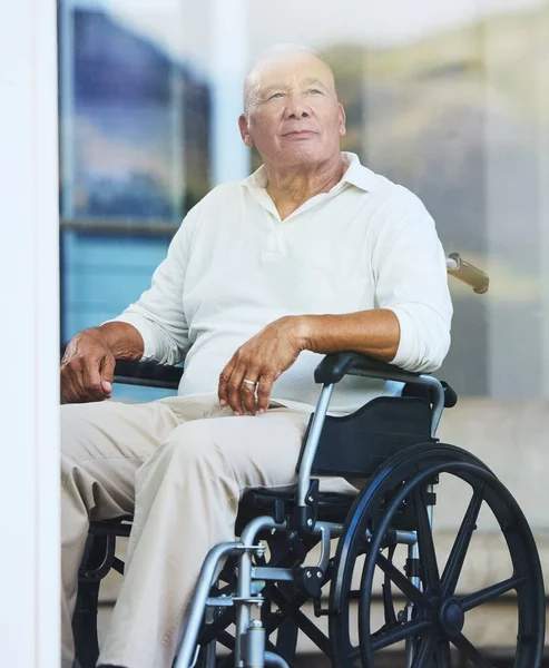 stock image Retirement, window and elderly man in wheelchair thinking about life in luxury Portugal nursing home, estate or village. Senior Care, disability and homecare for disabled person with support and help.