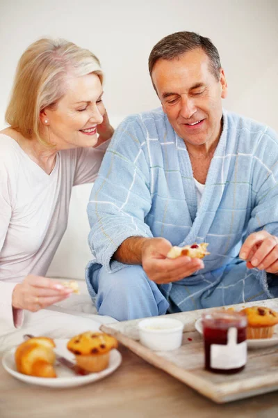 Couple having breakfast with a mature man applying jam. Portrait of a happy couple having breakfast with a mature man applying jam