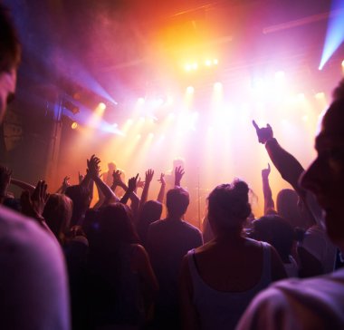 Kalabalık, sahne ışıkları ve parti etkinliklerinde canlı müzik, gece kulübü festivali veya dans pisti konseri. İnsanlar, müzisyenler ve seyirciler spot ışıkları altında dans ediyorlar sosyal disko, tekno-parti veya rock eğlence.