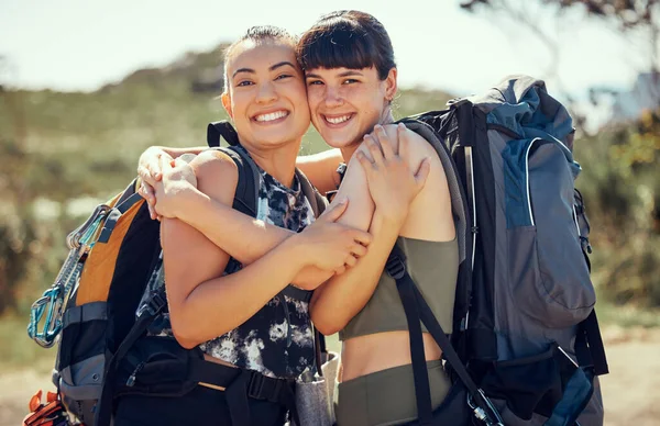 Women mountain hiking, friends hug in nature and outside in summer sun freedom. An adventure hike is great for exercise, fitness training and cardio with friend on hills of a local natural landscape.