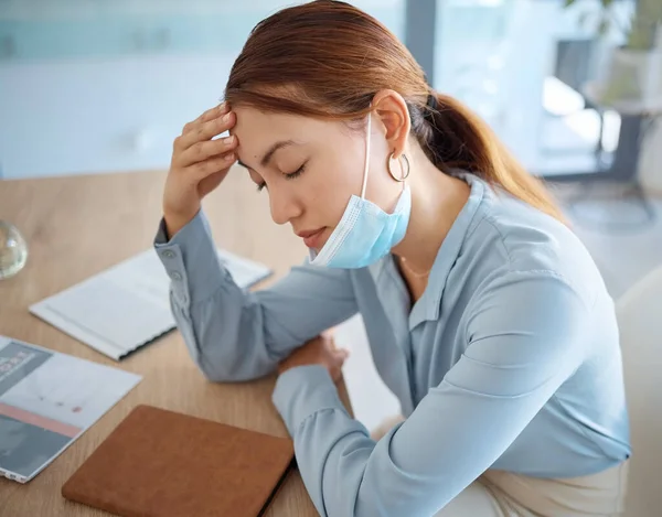 Stress, covid fatigue and woman with headache pain at in the office at work suffering from illness and sickness virus. Tired, mental health and person with migraine sleeping on the job in a mask.