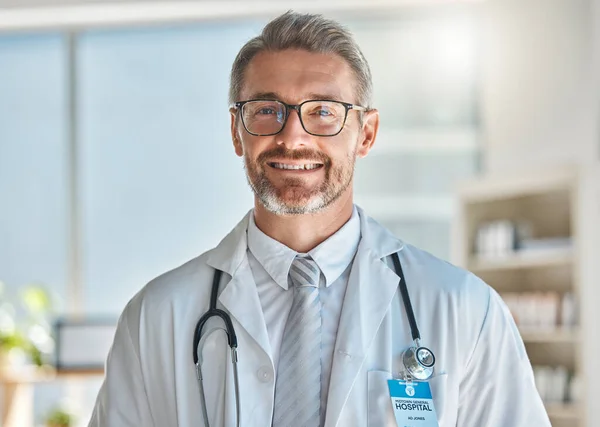 Doctor, smile and office working at hospital, clinic or medical facility. Medic, man and happy at work with stethoscope, glasses and happiness on face in portrait at healthcare center in Atlanta.