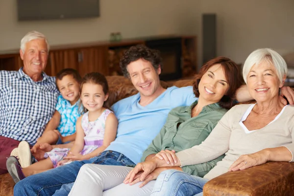 一つの大きな幸せな家族として自由な時間を 幸せな多世代の家族がソファに座って — ストック写真