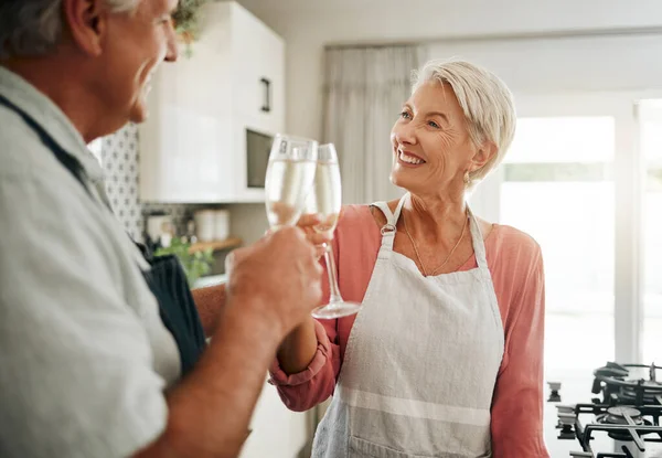 上了年纪的夫妇 在结婚周年纪念日 庆祝活动或退休保障成功的时候 在家里或家里厨房里喝香槟和吐司 快乐的微笑 爱情的老人 女人和酒精的酒杯 — 图库照片