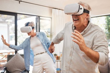 VR, 3D teknoloji ve evin oturma odasında birlikte oyun oynayan yaşlı çift. Mutlu, heyecanlı ve komik yaşlı adam ve kadın salonda dijital video oyunu oynuyorlar..