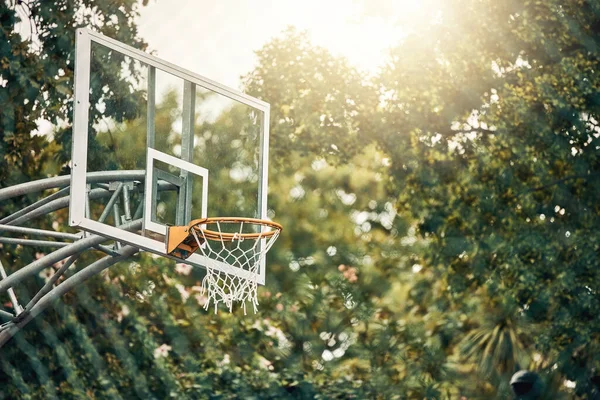 Nature, basketball court and basket for fitness training and game tournament score exercise. Outdoor sports venue net for competition goal practice and cardio workout with sunshine flare
