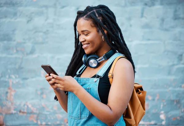 웃으세요 헤드폰을 자메이카 학생의 전화입니다 인터넷 미디어를 사용하고 메시지를 행복하게 — 스톡 사진