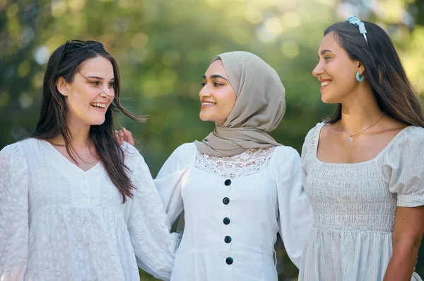 Diversity, friends and happy with women smile for support, trust and community together. Multicultural, freedom and happiness with young females standing in countryside for fashion, muslim and youth.
