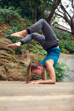 Hayata farklı bir açıdan bakmak. Dışarıda yoga yapan genç bir kadın.