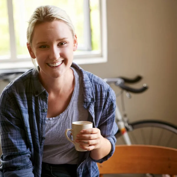 Feeling relaxed at home. Portrait of an attractive young woman having coffee at home