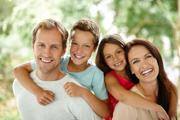 彼らは親密な家族です 4人の幸せな家族の肖像屋外で一緒に過ごす時間 — ストック写真
